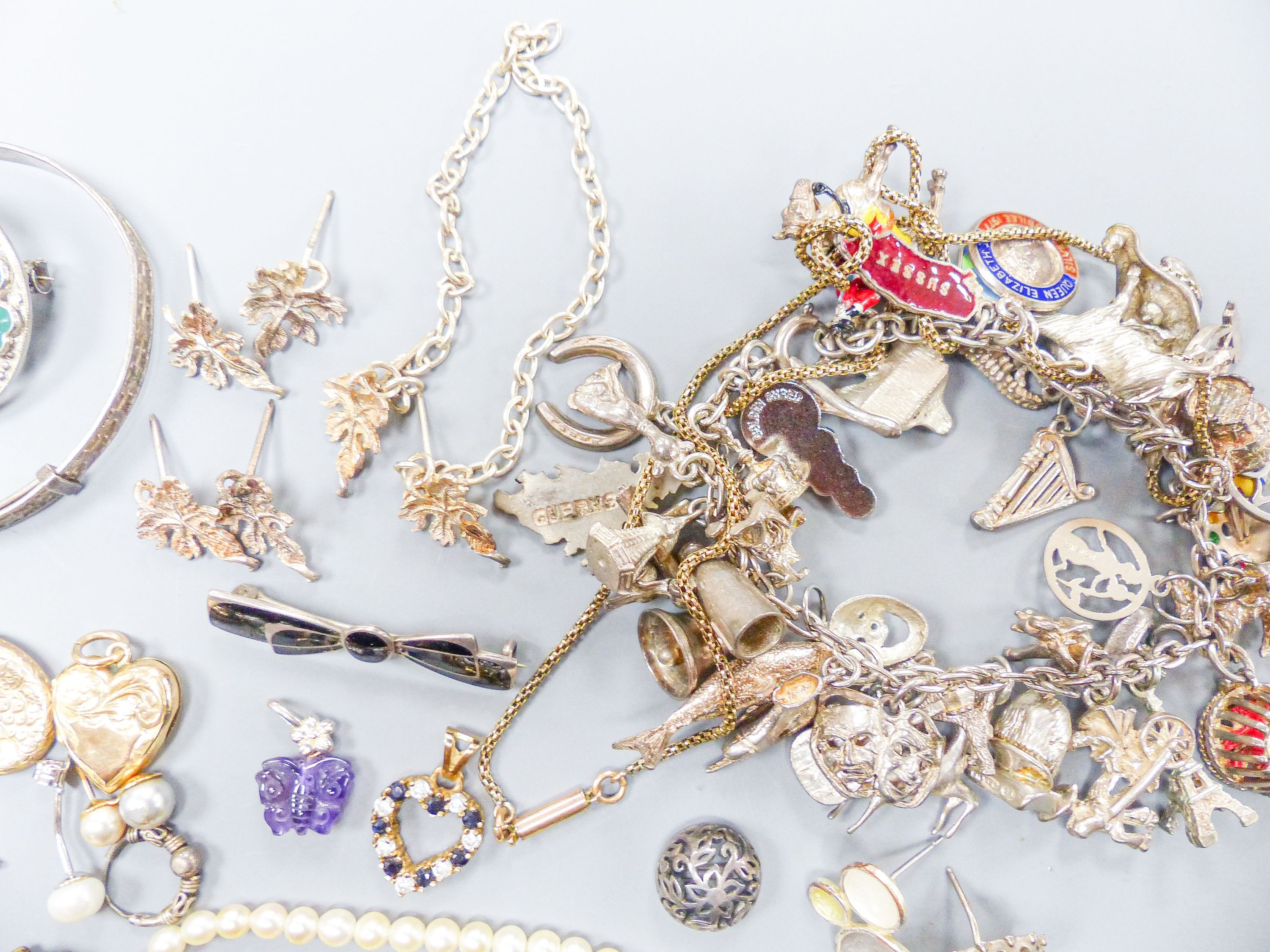 Assorted gold and silver jewellery including bar brooches, charm bracelet etc.
